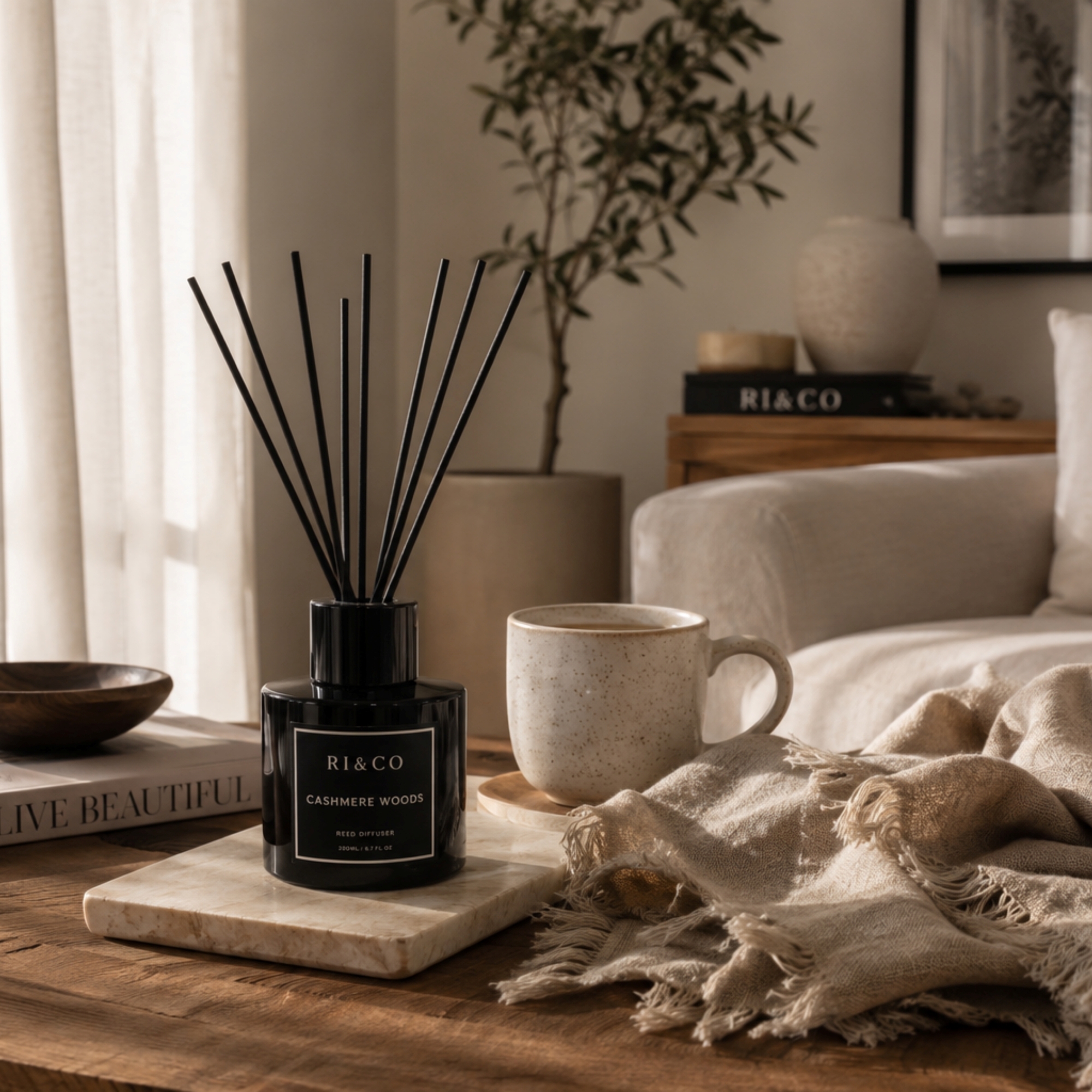 Luxury living room featuring a RI&CO Cashmere Woods reed diffuser creating a calm and relaxing home environment.